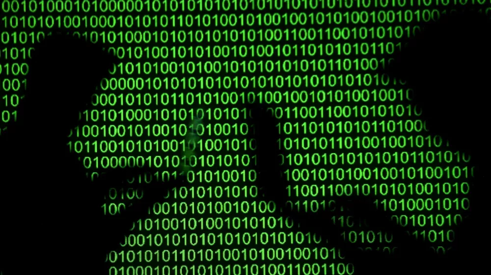 FILE PHOTO: Silhouettes of laptop users are seen next to a screen projection of binary code in this picture illustration created on March 28, 2018. REUTERS/Dado Ruvic/Illustration/File Photo