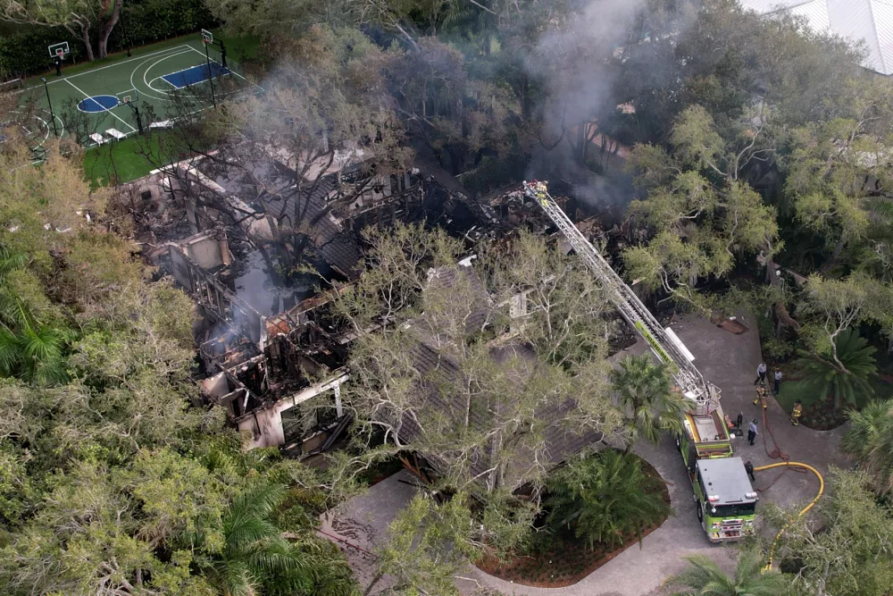 Firefighters work to extinguish the remains of a fire at a home owned by Miami Heat basketball coach Erik Spoelstra, Thursday, Nov. 6, 2025, in Miami. (AP Photo/Rebecca Blackwell)