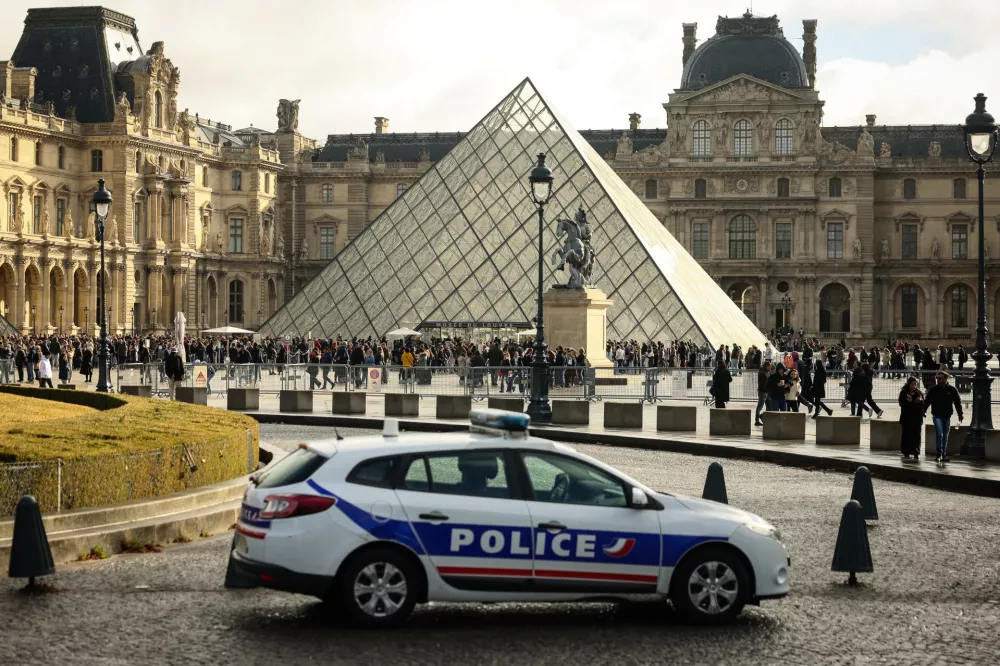 FILE - A police car parks in the courtyard of the Louvre museum, one week after the robbery, on Oct. 26, 2025, in Paris. (AP Photo/Thomas Padilla, File)