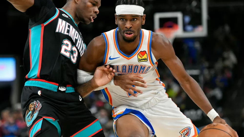 Oklahoma City Thunder guard Shai Gilgeous-Alexander, right, handles the ball against Memphis Grizzlies forward Cedric Coward (23) in the second half of an NBA basketball game Sunday, Nov. 9, 2025, in Memphis, Tenn. (AP Photo/Brandon Dill)