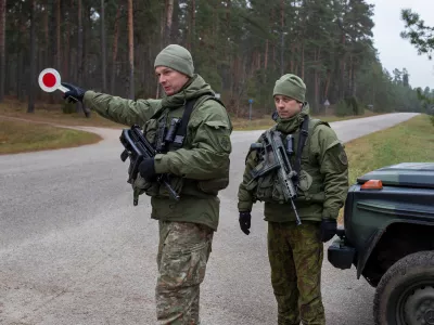 FILE - Lithuanian soldiers patrol a road near the Lithuania-Belarus border near the village of Jaskonys, Druskininkai district some 160 km (100 miles) south of the capital Vilnius, Lithuania, on Nov. 13, 2021. (AP Photo/Mindaugas Kulbis, File)