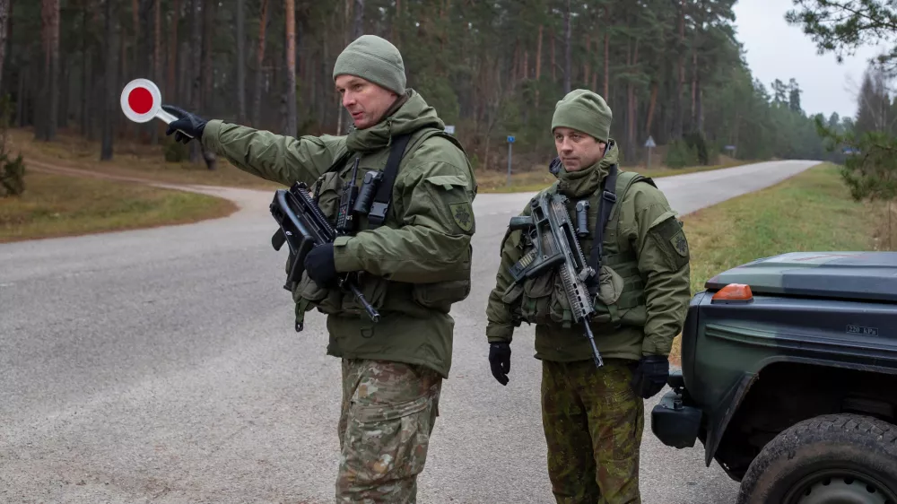 FILE - Lithuanian soldiers patrol a road near the Lithuania-Belarus border near the village of Jaskonys, Druskininkai district some 160 km (100 miles) south of the capital Vilnius, Lithuania, on Nov. 13, 2021. (AP Photo/Mindaugas Kulbis, File)