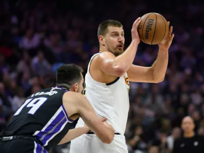 Denver Nuggets center Nikola Jokić, right, prepares to pass the ball past Sacramento Kings forward/center Drew Eubanks (19) during the first half of an NBA basketball game in Sacramento, Calif., Tuesday, Nov. 11, 2025. (AP Photo/Randall Benton)