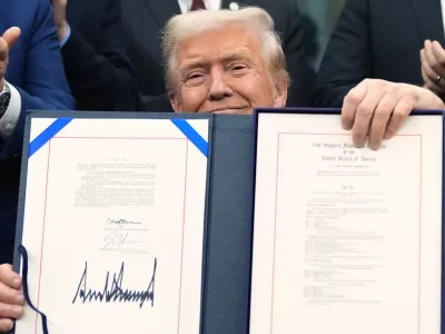 President Donald Trump displays the signed the funding bill to reopen the government, in the Oval Office of the White House, Wednesday, Nov. 12, 2025, in Washington. (AP Photo/Jacquelyn Martin)