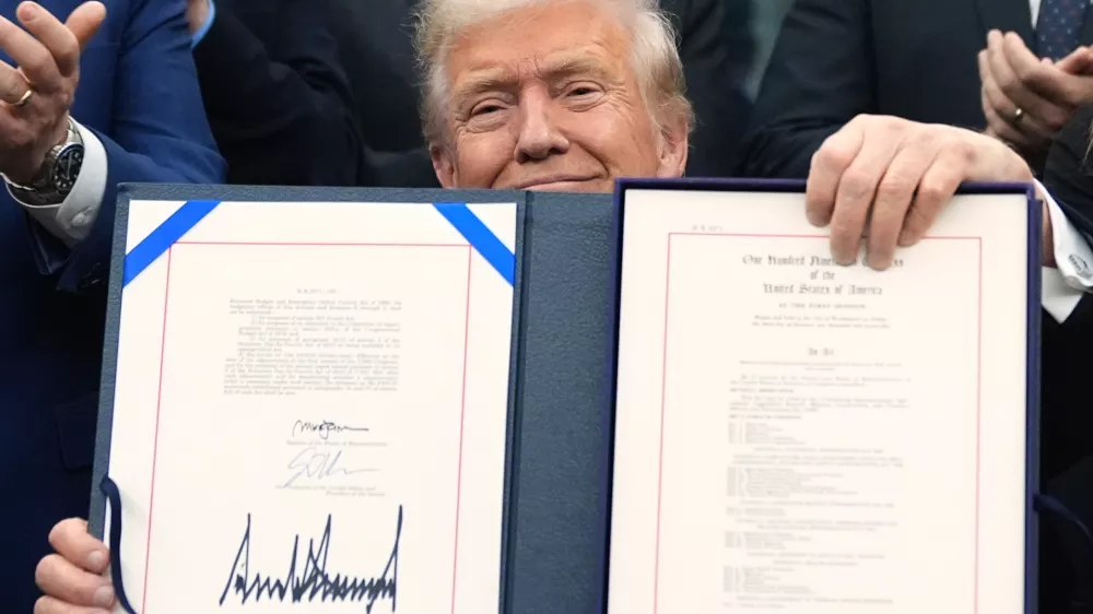 President Donald Trump displays the signed the funding bill to reopen the government, in the Oval Office of the White House, Wednesday, Nov. 12, 2025, in Washington. (AP Photo/Jacquelyn Martin)