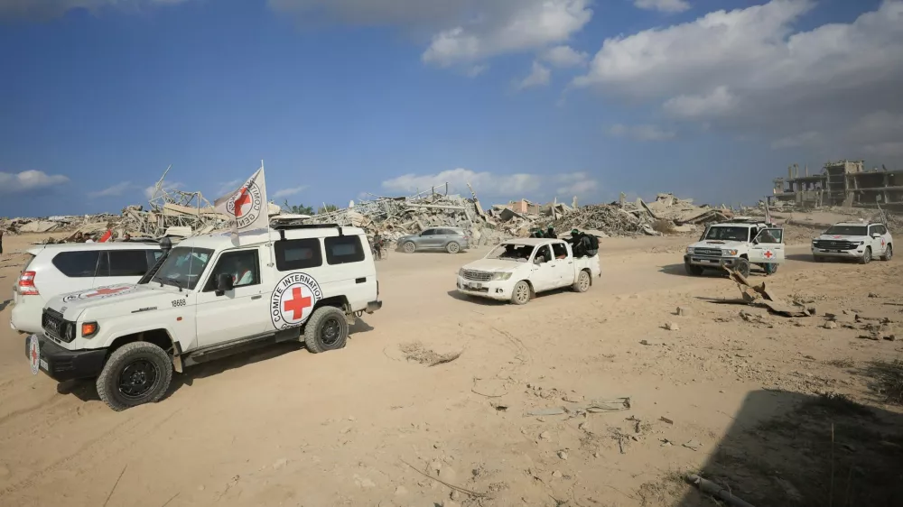 Red Cross personnel, escorted by Hamas militants, wait to head towards an area within the so-called "yellow line" to which Israeli troops withdrew under the ceasefire, as Hamas says it continues to search for the bodies of deceased hostages seized during the October 7, 2023, attack on Israel, in Gaza City November 12, 2025. REUTERS/Dawoud Abu Alkas
