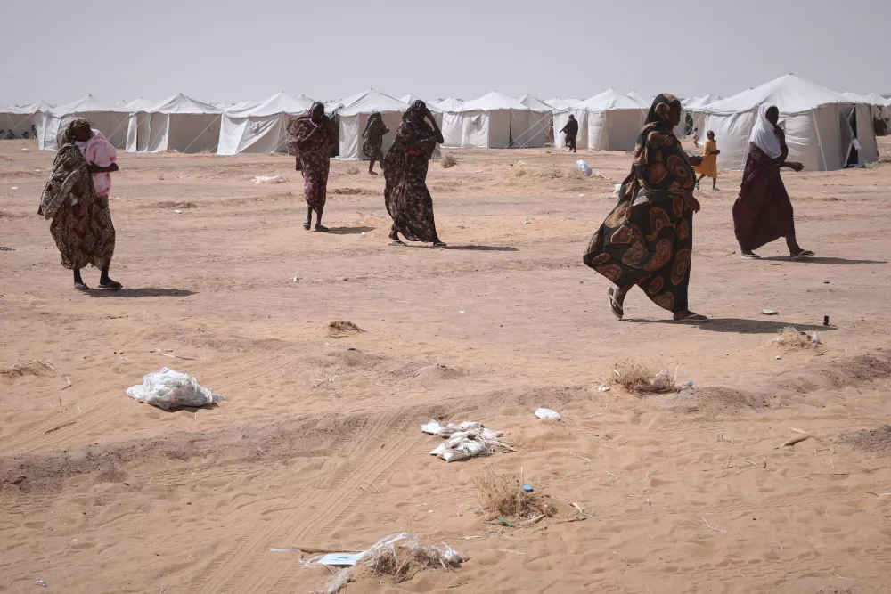 Sudanese women displaced from el-Fasher, the capital of North Darfur, and other conflict-affected areas walk through the newly established El-Afadh camp in Al Dabbah, Northern State, Sudan, on Thursday, Nov. 13, 2025. (AP Photo/Marwan Ali)