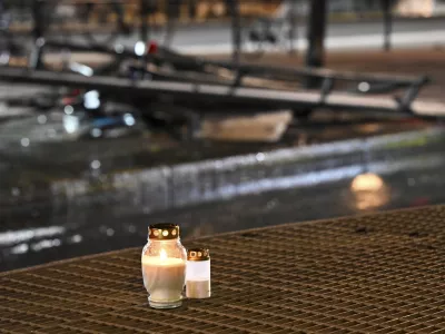 Candles for victims sit at the scene of the accident after a bus crashed into a bus stop in &Ouml;stermalm in Stockholm, Sweden, Friday. Nov. 14, 2025. (Henrik Montgomery/TT News Agency via AP)