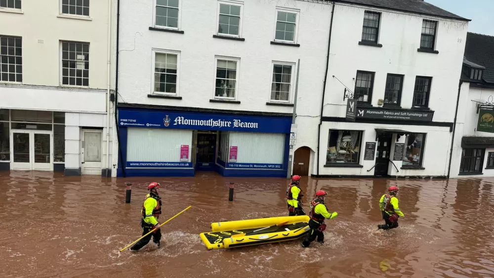 Rescue workers wade through floodwater after severe flooding in south Wales, as Storm Claudia reaches parts of the United Kingdom, in Monmouth, Wales, Britain, November 15, 2025 in this picture obtained from social media. Kim Kaos/via REUTERS THIS IMAGE HAS BEEN SUPPLIED BY A THIRD PARTY. MANDATORY CREDIT. NO RESALES. NO ARCHIVES.  VERIFICATION: Reuters was able to verify the location from the design of the buildings, position of the road and shop signs which matched file and satellite imagery of the area. That was confirmed from the original file metadata.
