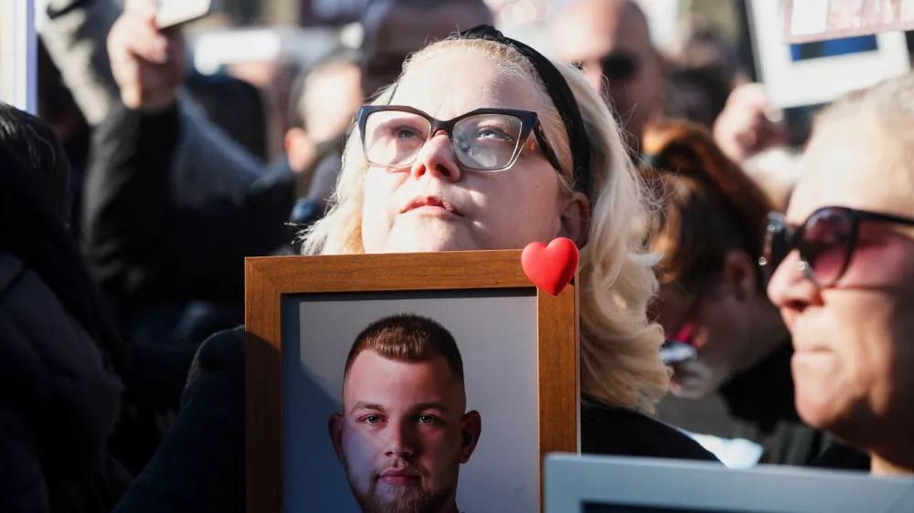 A woman holds a picture of a Kocani nightclub fire victim during a protest in Skopje, North Macedonia, on Saturday, Nov. 15, 2025, just a few days before the start of the trial for the fire. (AP Photo/Boris Grdanoski)