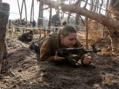 Civilians practice military skills on a training ground in Kharkiv region, Ukraine, Saturday, Nov. 15, 2025. (AP Photo/Andrii Marienko)