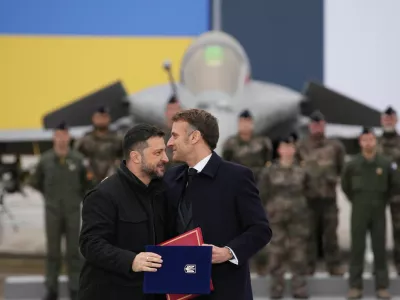French President Emmanuel Macron and Ukrainian President Volodymyr Zelenskiy hug after signing an agreement at the Villacoublay air base near Paris, France, November 17, 2025. Christophe Ena/Pool via REUTERS