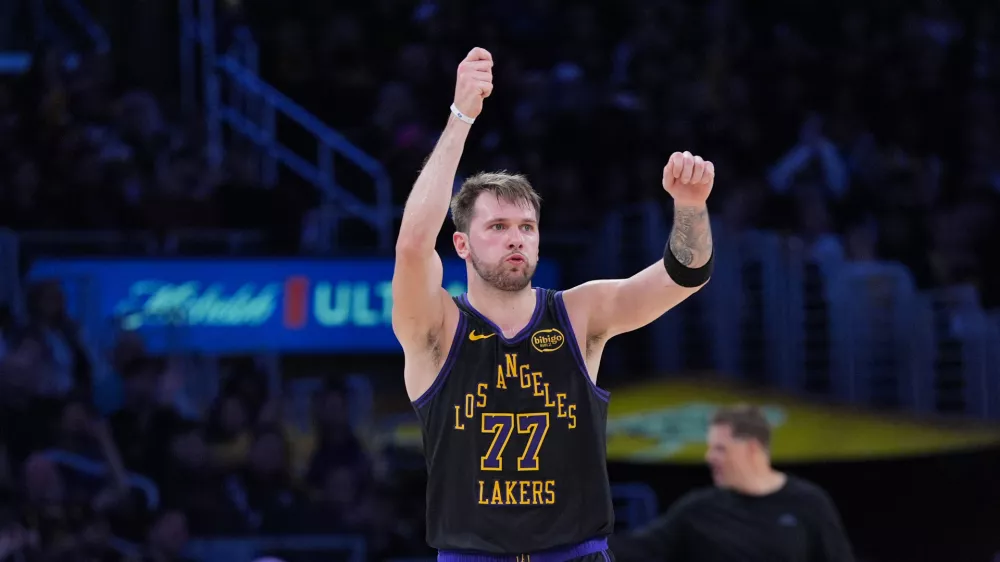 Los Angeles Lakers guard Luka Doncic (77) celebrates after making a three-point basket during the first half of an NBA basketball game against the Utah Jazz Tuesday, Nov. 18, 2025, in Los Angeles. (AP Photo/Jae C. Hong)