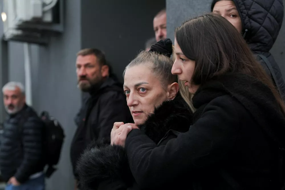 Family members look on while North Macedonian police escort the suspects over the deadly Kocani nightclub fire at the courthouse in Idrizovo, North Macedonia, November 19, 2025. Thirty seven people have been charged in connection with the fatal disco fire in Kocani in March, which killed 63 people. REUTERS/Valdrin Xhemaj