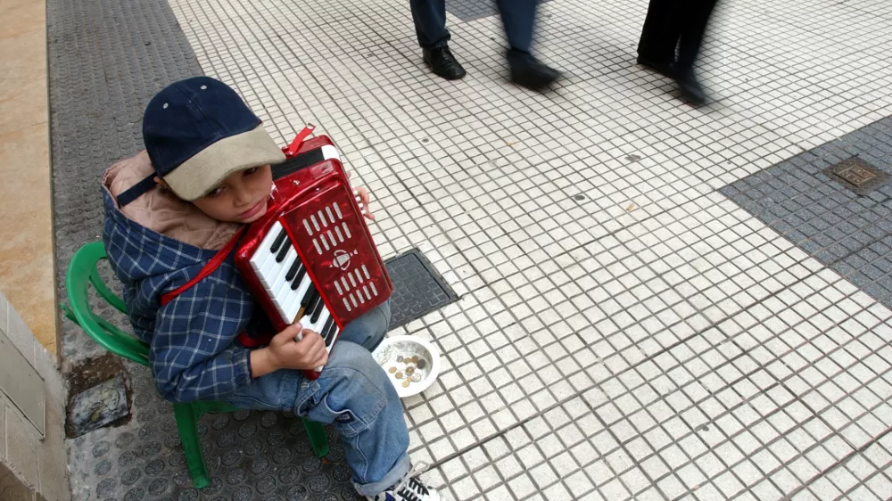 A child identified as Belusa plays acordion trying to get some coins in Buenos Aires, Tuesday, May 20, 2003.. Many question whether Nestor Kirchner, Argentina's next president, can quickly raise living standards in a country where one in five doesn't have a job and 60 percent live below the poverty level. (AP Photo/Natacha Pisarenko)