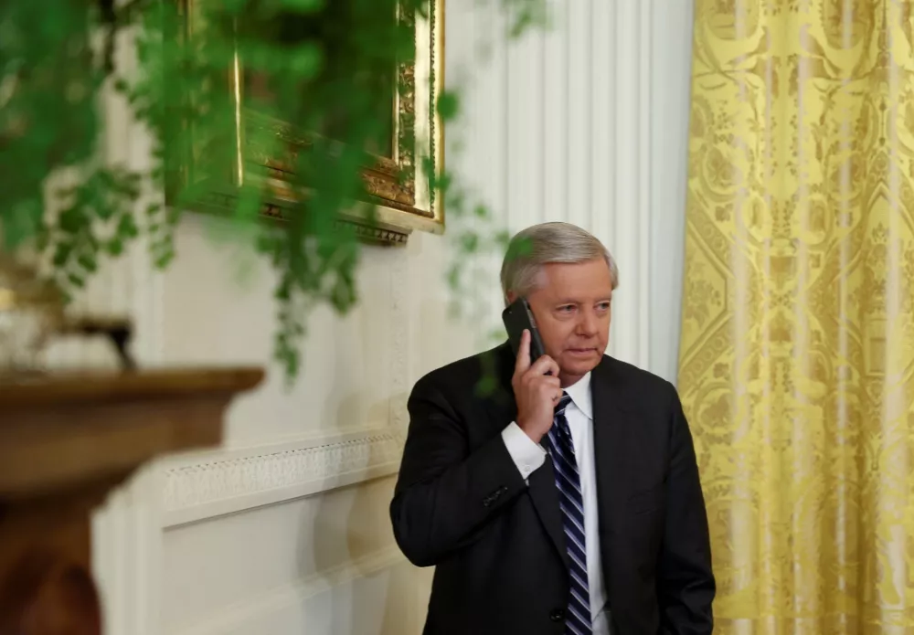 U.S. Senators Lindsey Graham (R-SC) uses his phone as he attends the signing into law of the "Ending Forced Arbitration of Sexual Assault and Sexual Harassment Act of 2021", at the White House in Washington, U.S., March 3, 2022. REUTERS/Evelyn Hockstein