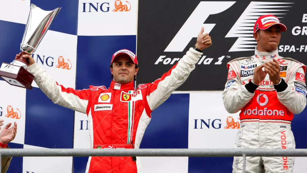 FILE PHOTO: Ferrari Formula One driver Felipe Massa (L) puts a thumb up while standing on the podium next to McLaren Formula One driver Lewis Hamilton of Britain (R) after the Belgian Grand Prix at the Spa-Francorchamps race track September 7, 2008. REUTERS/Yves Herman (BELGIUM)/File Photo