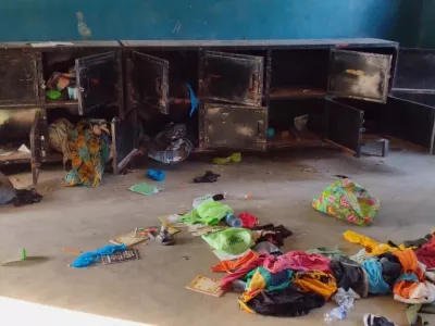 In this photo released by Christian Association of Nigeria, a man walk past belongings at the St. Mary's Catholic Primary and Secondary School after gunmen abducted children and staff in Papiri community, Nigeria, Friday, Nov. 21, 2025. (Christian Association of Nigeria via AP)