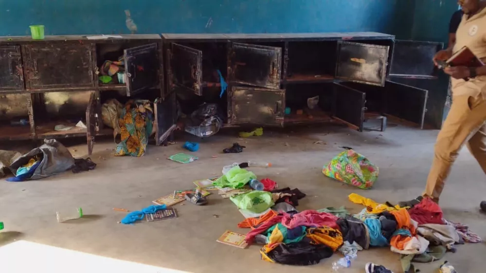 In this photo released by Christian Association of Nigeria, a man walk past belongings at the St. Mary's Catholic Primary and Secondary School after gunmen abducted children and staff in Papiri community, Nigeria, Friday, Nov. 21, 2025. (Christian Association of Nigeria via AP)