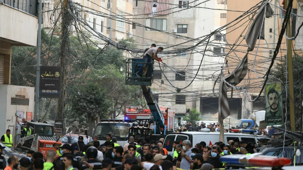 Civil defence members work as people gather near the site of an Israeli strike, after Israeli military said on Sunday that it struck a militant from the Lebanese Iran-aligned Hezbollah group, in Beirut's southern suburbs, Lebanon November 23, 2025. REUTERS/Mohamed Azakir