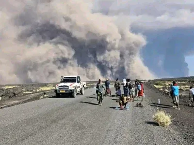 CAPTION CORRECTS HISTORY OF THE VOLCANO - In this photo released by the Afar Government Communication Bureau, people watch ash billow from an eruption of the long-dormant Hayli Gubbi Volcano in Ethiopia's Afar region, Sunday, Nov. 23, 2025. (Afar Government Communication Bureau via AP)