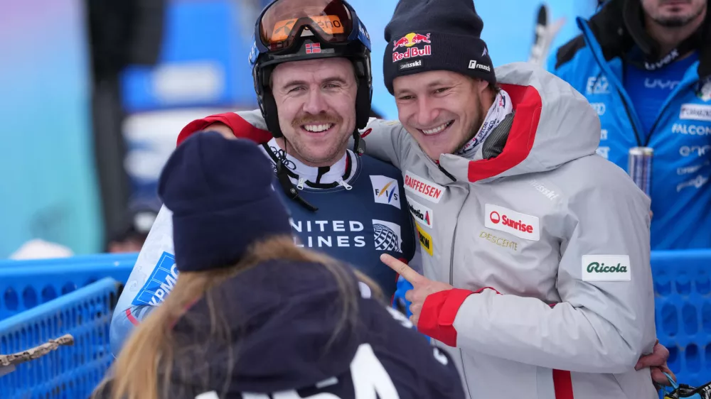 Nov 27, 2025; Copper, Colorado, USA; Aleksander Aamodt Kilde of Norway gets a hug from Marco Odermatt of Switzerland as Mikaela Shiffrin looks on during the men's Super G alpine skiing race at the Stifel Copper Cup at Copper Mountain. Mandatory Credit: Michael Madrid-Imagn Images