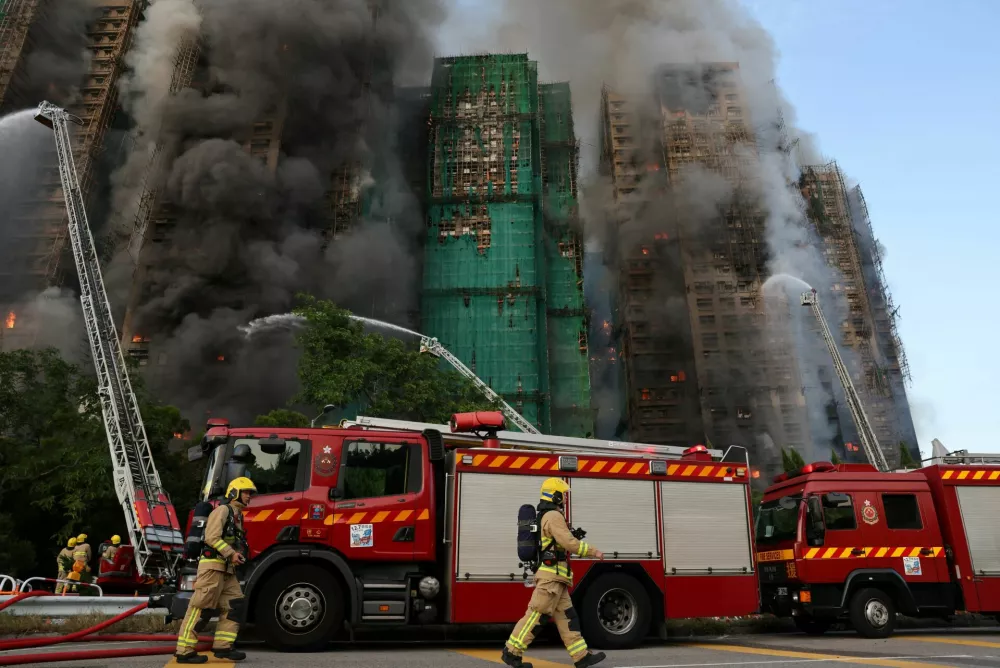Firefighters work as efforts are underway to extinguish flames engulfing bamboo scaffolding across multiple buildings at the Wang Fuk Court housing estate in Tai Po, Hong Kong, China, November 26, 2025. REUTERS/Tyrone Siu