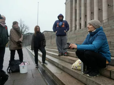 Juho-Pekka Palomaa, 33, sits on the steps in front of the Finnish parliament where he was holding a potluck protest to mark 1000 days of unemployment, in Helsinki, Finland, October 30, 2025. REUTERS/Tom Little