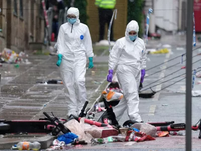 FILE - Forensic officers examine the site where a British man plowed a minivan into a crowd of Liverpool soccer fans who were celebrating the city's Premier League championship, injuring more than 45 people in Liverpool, England, May 27, 2025. (AP Photo/Jon Super, File)