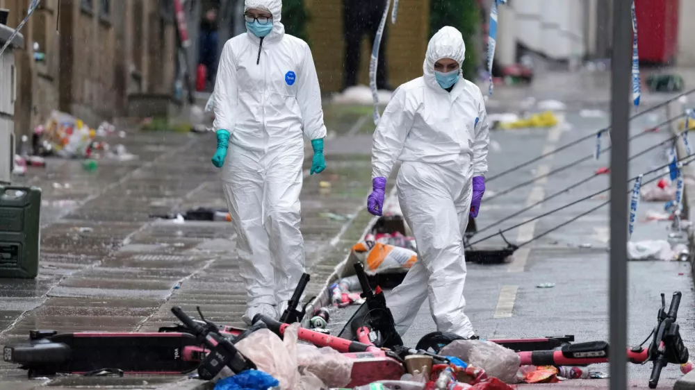 FILE - Forensic officers examine the site where a British man plowed a minivan into a crowd of Liverpool soccer fans who were celebrating the city's Premier League championship, injuring more than 45 people in Liverpool, England, May 27, 2025. (AP Photo/Jon Super, File)