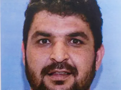 A picture of Rahmanullah Lakanwal, an Afghan national who is the suspect in the shooting of two National Guard members, is displayed at a press conference with FBI Director Kash Patel, attorney Jeanine Pirro and other authorities, in Washington, D.C., U.S., November 27, 2025. REUTERS/Nathan Howard