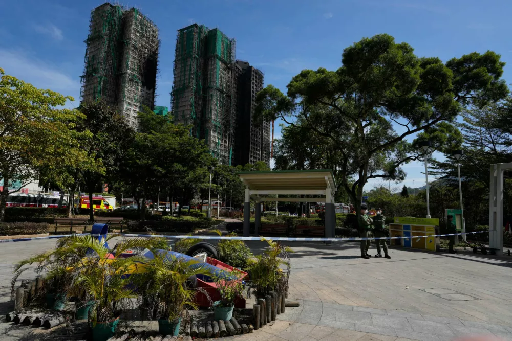 Hong Kong police officers stand on duty near the site of a fire at Wang Fuk Court, a residential estate in the Tai Po district of Hong Kong's New Territories, Friday, Nov. 28 2025. (AP Photo/Ng Han Guan)