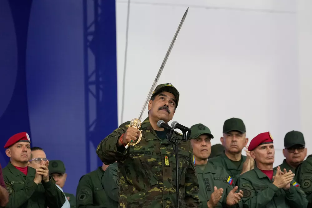 Venezuelan President Nicolas Maduro brandishes a sword said to have belonged to independence hero Simon Bolivar during a civic-military event at the military academy in Caracas, Venezuela, Tuesday, Nov. 25, 2025. (AP Photo/Ariana Cubillos)