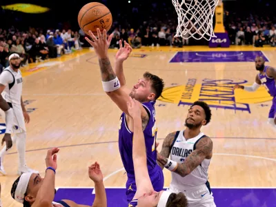 Nov 28, 2025; Los Angeles, California, USA; Los Angeles Lakers guard Luka Doncic (77) reaches for a rebound in the second half against the Dallas Mavericks at Crypto.com Arena. Mandatory Credit: Jayne Kamin-Oncea-Imagn Images