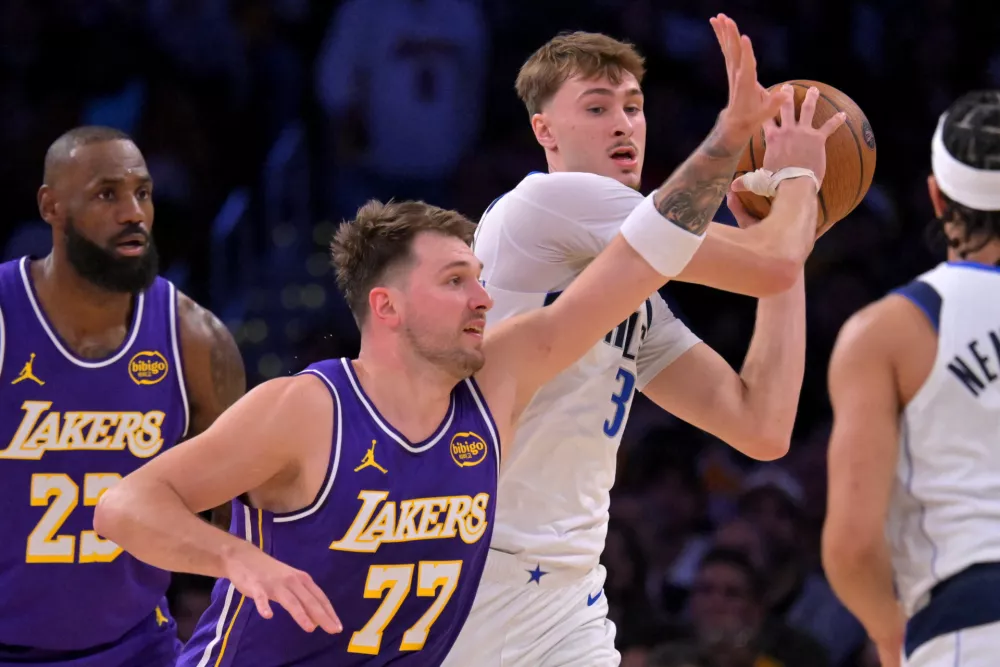 Nov 28, 2025; Los Angeles, California, USA; Dallas Mavericks forward Cooper Flagg (32) is defended by Los Angeles Lakers guard Luka Doncic (77) in the first half at Crypto.com Arena. Mandatory Credit: Jayne Kamin-Oncea-Imagn Images