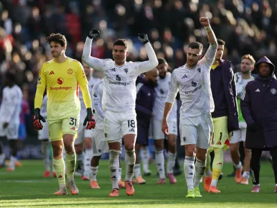 Soccer Football - Premier League - Crystal Palace v Manchester United - Selhurst Park, London, Britain - November 30, 2025 Manchester United's Senne Lammens, Casemiro and Diogo Dalot celebrate after the match Action Images via Reuters/John Sibley EDITORIAL USE ONLY. NO USE WITH UNAUTHORIZED AUDIO, VIDEO, DATA, FIXTURE LISTS, CLUB/LEAGUE LOGOS OR 'LIVE' SERVICES. ONLINE IN-MATCH USE LIMITED TO 120 IMAGES, NO VIDEO EMULATION. NO USE IN BETTING, GAMES OR SINGLE CLUB/LEAGUE/PLAYER PUBLICATIONS. PLEASE CONTACT YOUR ACCOUNT REPRESENTATIVE FOR FURTHER DETAILS..