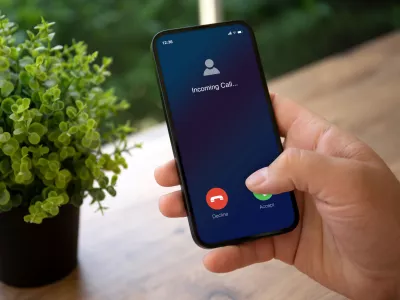 man hands holding phone with incoming call on screen in green cafe / Foto: Prykhodov