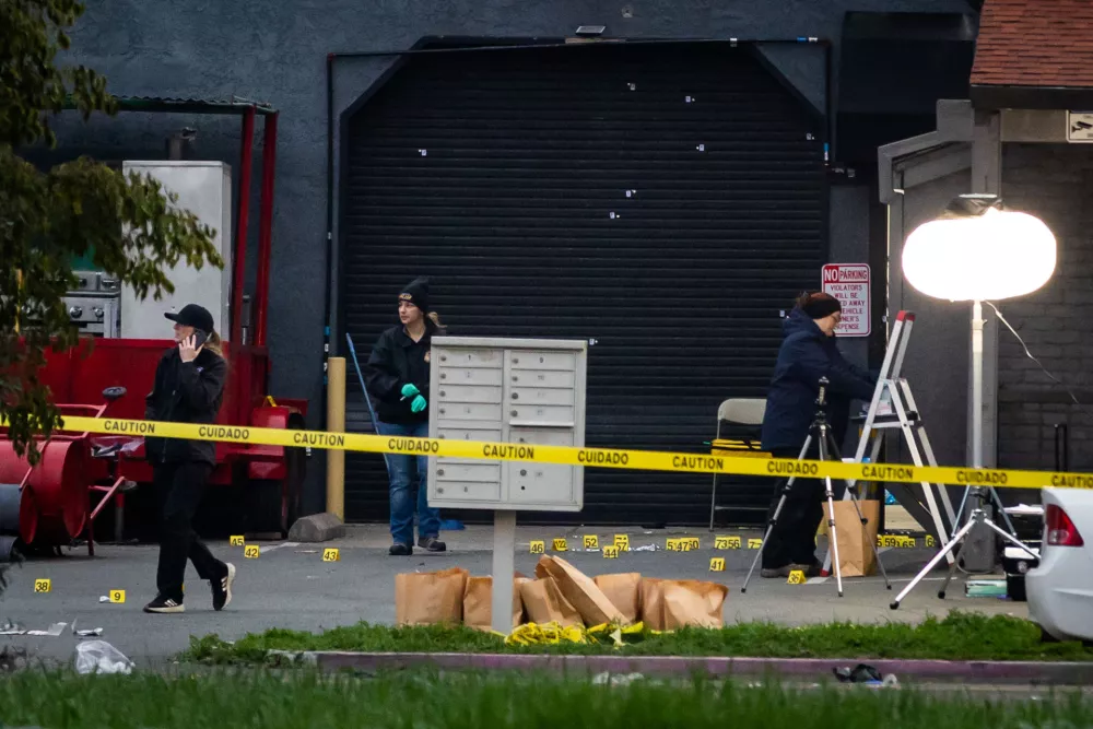 Investigators examine the scene of a mass shooting Sunday, Nov. 30, 2025, in Stockton, Calif. (AP Photo/Ethan Swope)