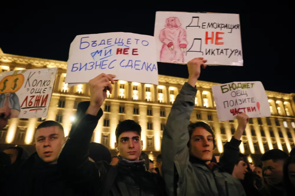 People hold posters read from left: "How many more lies?", "The future is not a business deal", "Democracy is not a dictatorship" and "The budget is public, the benefits are private" during a rally against austerity measures in next year's draft budget, in Sofia, Monday, Dec 1, 2025. (AP Photo/Valentina Petrova)