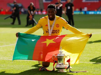 FILE PHOTO: Soccer Football - FA Cup - Final - Manchester City v Manchester United - Wembley Stadium, London, Britain - May 25, 2024 Manchester United's Andre Onana poses with the flag of Cameroon and the trophy as he celebrates after winning the FA Cup Action Images via Reuters/Andrew Couldridge/File Photo