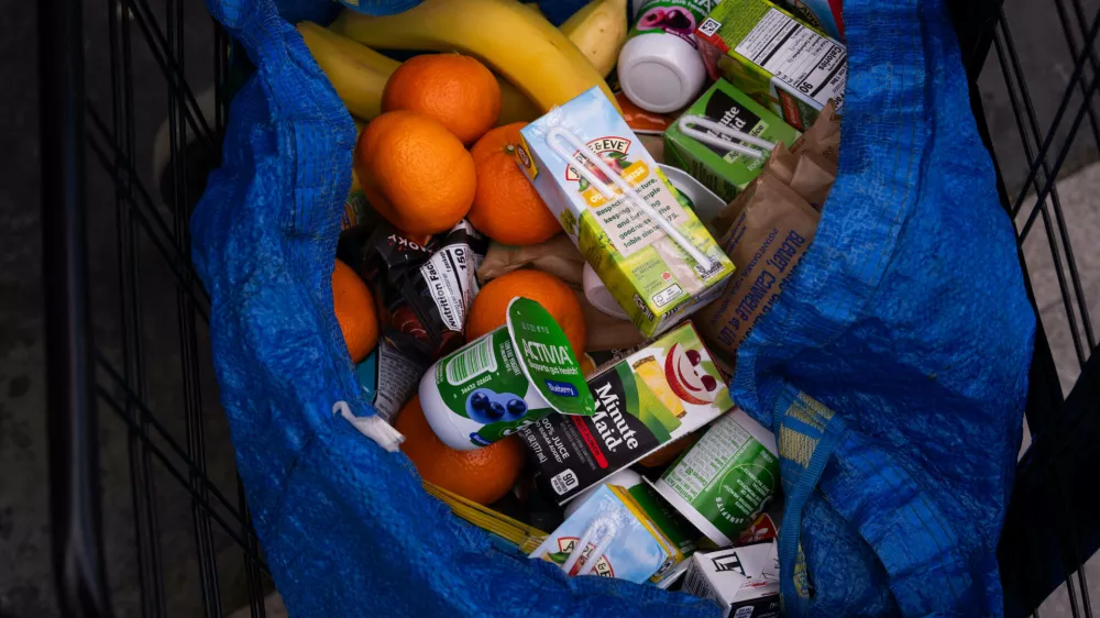 A person stocks their trolley with food from a One Love Community Fridge, Nov. 15, 2025, in Brooklyn, New York. (AP Photo/Adam Gray)