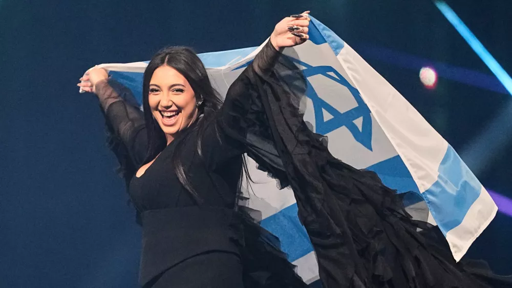 FILE - Singer Yuval Raphael, from Israel, holds the national flag during a dress rehearsal for the Grand Final of the 69th Eurovision Song Contest, May 16, 2025, in Basel, Switzerland. (AP Photo/Martin Meissner, File)
