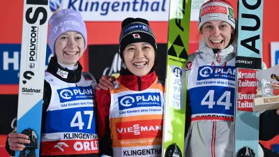 Nozomi Maruyam, center, of Japan, winner of the ski jumping, women's World Cup large hill event, poses on the podium with second placed Nika Prevc of Slovenia, left, and third placed Lisa Eder of Austria, in Klingenthal, Germany, Friday, Dec. 12, 2025. (Hendrik Schmidt/dpa via AP)