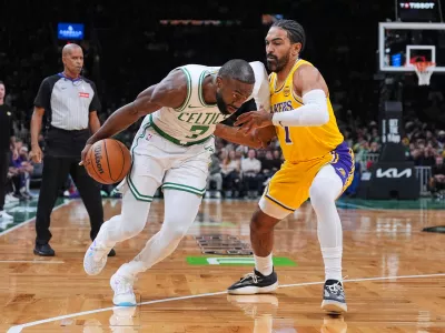 Boston Celtics guard Jaylen Brown, left, drives to the basket against Los Angeles Lakers guard Gabe Vincent, right, during the first half of an NBA basketball game, Friday, Dec. 5, 2025, in Boston. (AP Photo/Charles Krupa)