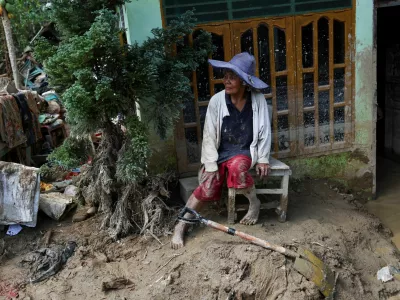Survivor Rismawati Simanjuntak, 63, sits as she takes a break while collecting valuable goods and cleaning her house following deadly flash flood in Batang Toru, South Tapanuli, North Sumatra province, Indonesia, December 6, 2025. REUTERS/Willy Kurniawan
