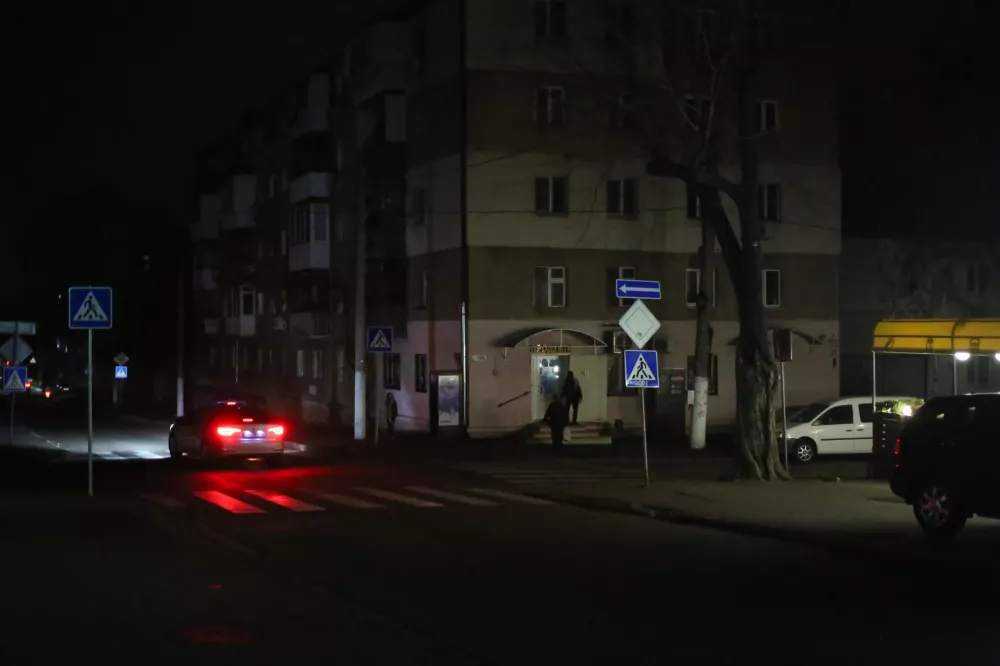 10 November 2025, Ukraine, OdessaA car is driven along a dark street Nezhinskaya. Due to damage to power distribution stations caused by shelling by the Russian Federation, scheduled power outages are in effect in Odessa. DTEK, the largest private energy company in Ukraine is shutting off power daily for distribution and production according to schedule. PhotoViacheslav Onyshchenko/SOPA Images via ZUMA Press Wire/dpa