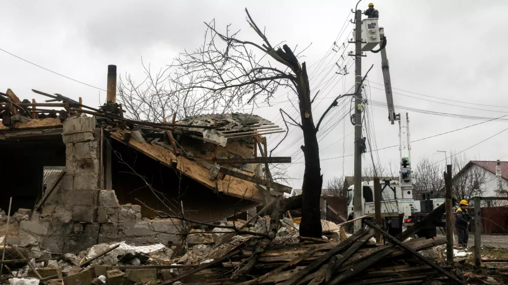 A worker of the DTEK energy company fixes power lines outside a house that was damaged during a night of Russian missile and drone strikes, amid Russia's attack on Ukraine, in Novi Petrivtsi, outside Kyiv, Ukraine, December 6, 2025. REUTERS/Thomas Peter