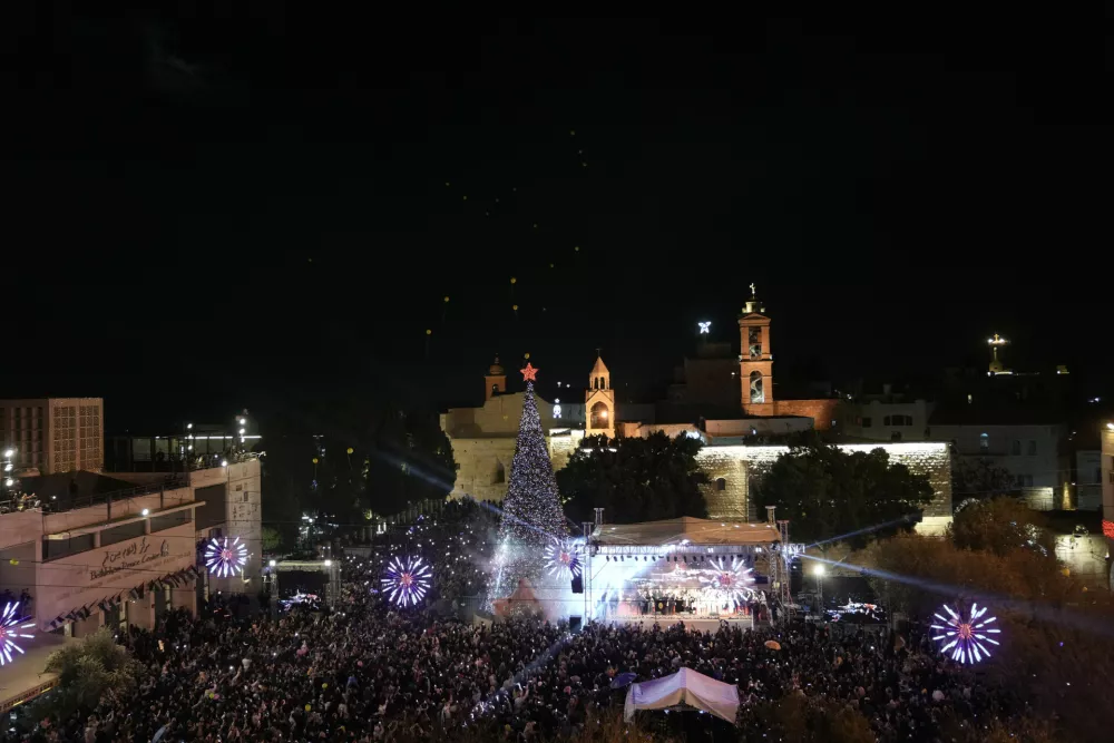 Palestinians take part in a Christmas tree&ndash;lighting event in Manger Square, next to the Church of the Nativity, traditionally regarded as the birthplace of Jesus Christ ahead of Christmas in the West Bank city of Bethlehem Saturday, Dec. 6, 2025. (AP Photo/Mahmoud Illean)