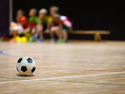 Football Futsal Ball and Youth Team. Indoor Soccer Sports Hall. Children Indoor Soccer Team. Sport Futsal background. Indoor Soccer Winter League for Kids