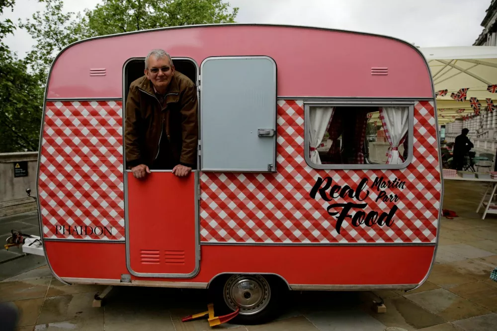 FILE PHOTO: Photographer Martin Parr looks out from his own caravan which is serving food at the Photo London show in London, Britain, May 18, 2016. REUTERS/Kevin Coombs/File Photo